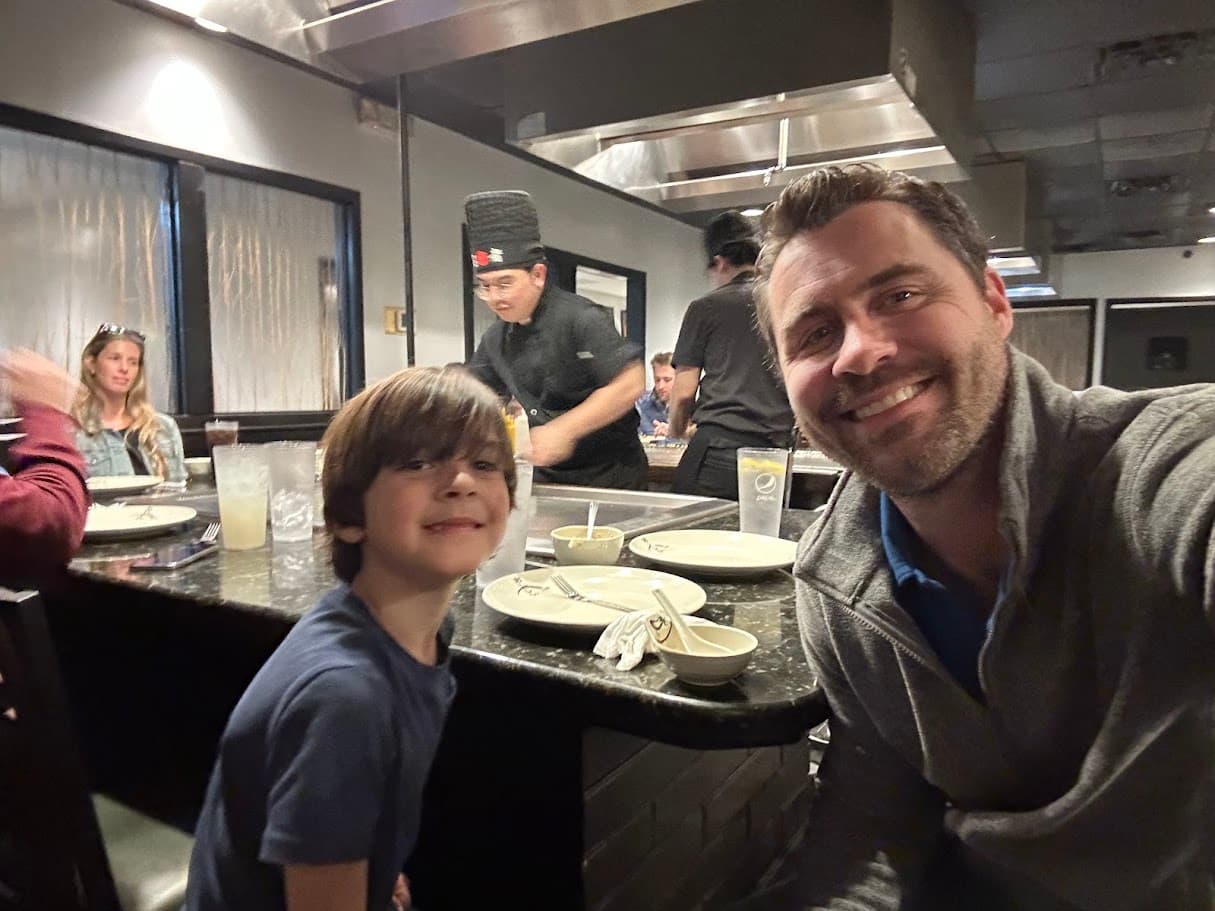 Kris and his son enjoying dinner together at a restaurant